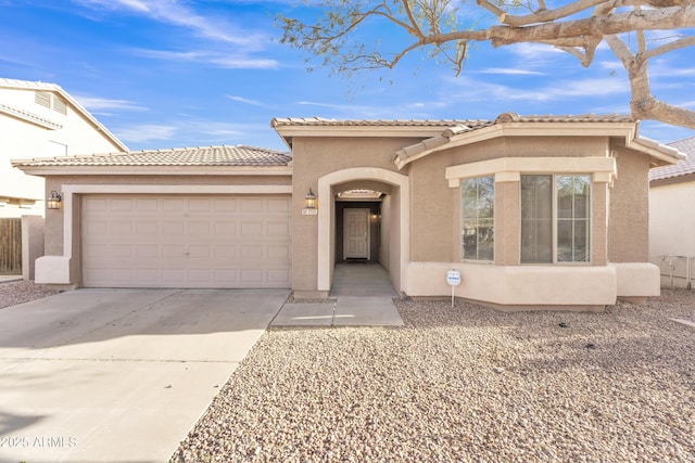 mediterranean / spanish-style home with a garage, a tile roof, driveway, and stucco siding