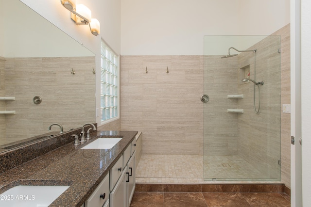 bathroom with double vanity, walk in shower, and a sink