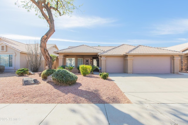 view of front facade featuring a garage, a tile roof, driveway, and stucco siding