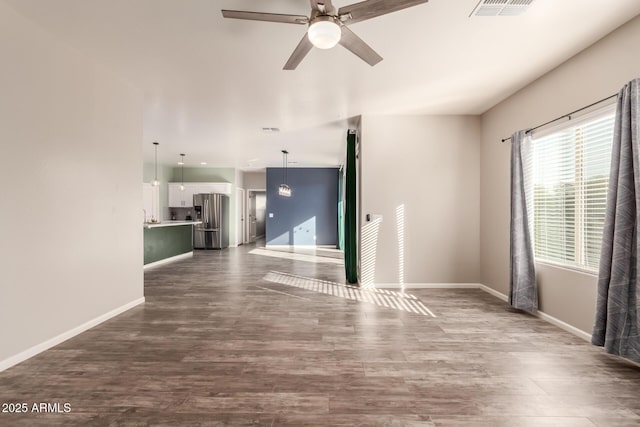 unfurnished living room with dark hardwood / wood-style flooring and ceiling fan