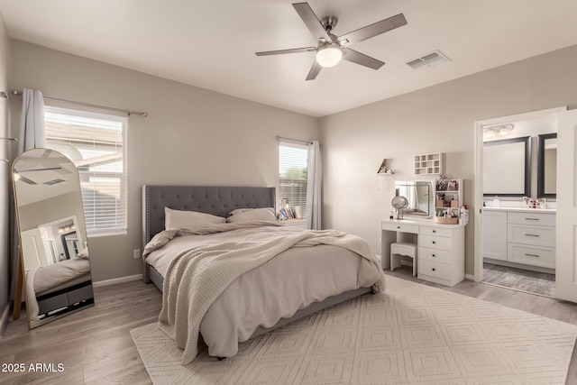 bedroom featuring connected bathroom, light hardwood / wood-style flooring, and ceiling fan