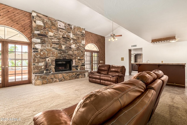 119 E Palomino Dr, Tempe, AZ 85284 - carpeted living room with high vaulted ceiling, healthy amount of natural light, a stone fireplace, a ceiling fan, and wooden walls