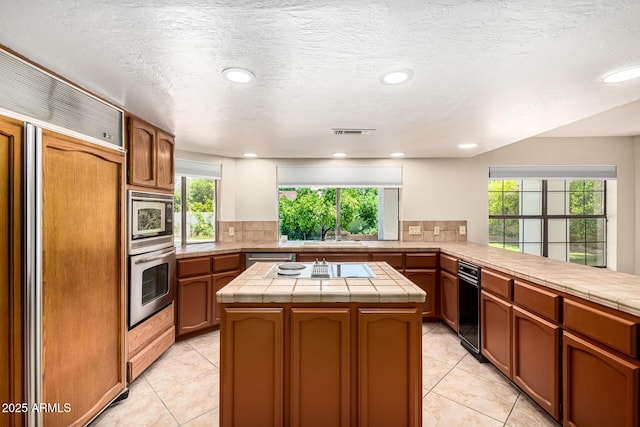 119 E Palomino Dr, Tempe, AZ 85284 - kitchen with built in appliances, a kitchen island, tile counters, light tile patterned flooring, and recessed lighting