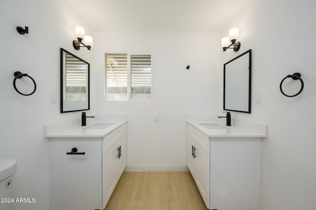 bathroom with wood-type flooring, toilet, and vanity