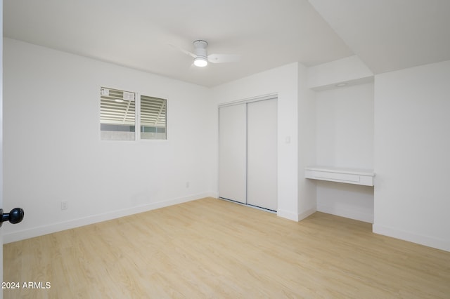 unfurnished bedroom with light hardwood / wood-style floors, ceiling fan, and a closet