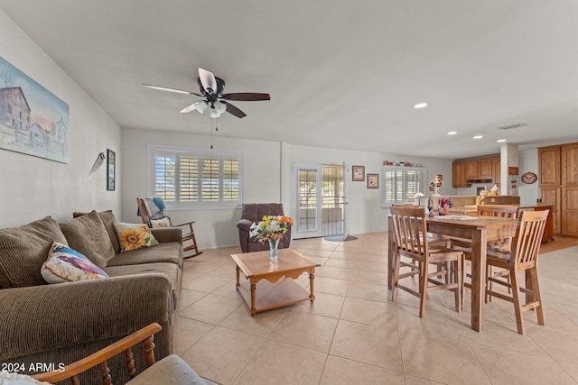 living room featuring ceiling fan, a wealth of natural light, and light tile flooring