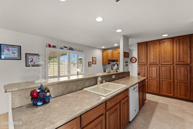 kitchen with light tile floors, white dishwasher, and sink