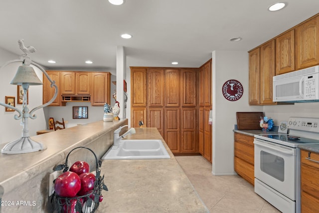 kitchen with light tile floors, white appliances, and sink