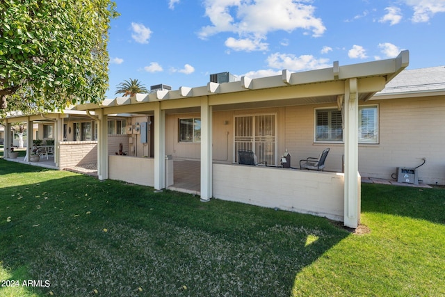 back of property with a yard and a patio area