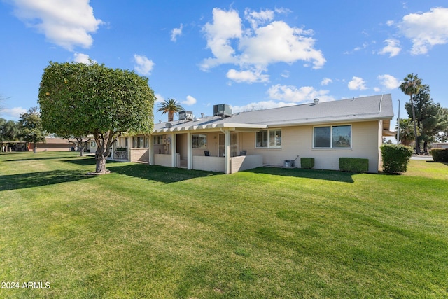 back of property featuring a lawn