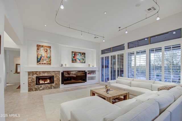 living room with tile patterned flooring and a high end fireplace