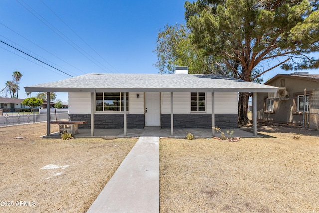 4048 W Granada Rd, Phoenix, AZ 85035 - ranch-style house with stone siding, covered porch, and a shingled roof