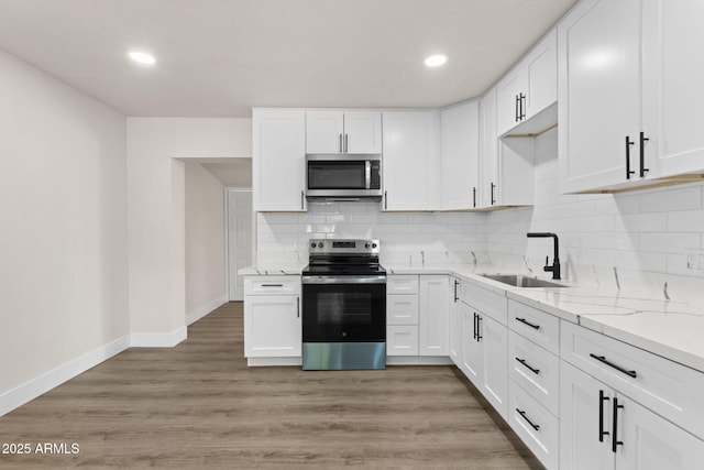 4048 W Granada Rd, Phoenix, AZ 85035 - kitchen with appliances with stainless steel finishes, decorative backsplash, white cabinetry, light stone countertops, and recessed lighting