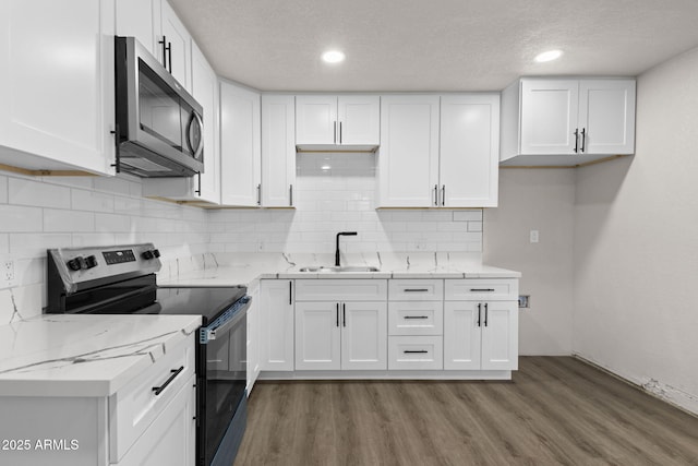 4048 W Granada Rd, Phoenix, AZ 85035 - kitchen with stainless steel appliances, white cabinets, wood finished floors, light stone countertops, and a textured ceiling
