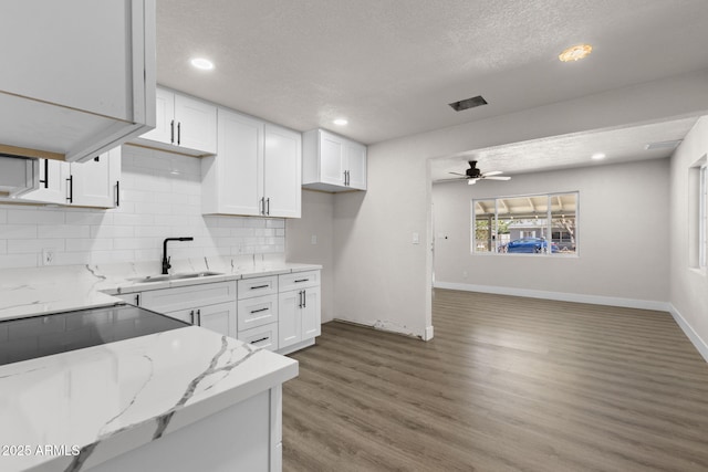 4048 W Granada Rd, Phoenix, AZ 85035 - kitchen with white cabinets, backsplash, light wood finished floors, ceiling fan, and plenty of natural light