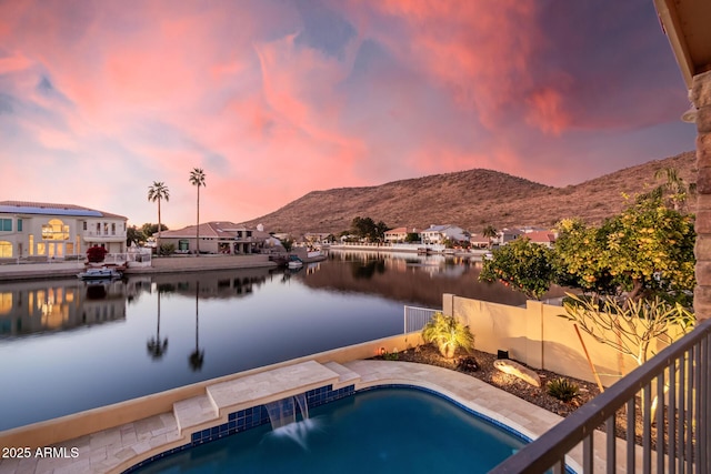 pool at dusk with a water and mountain view