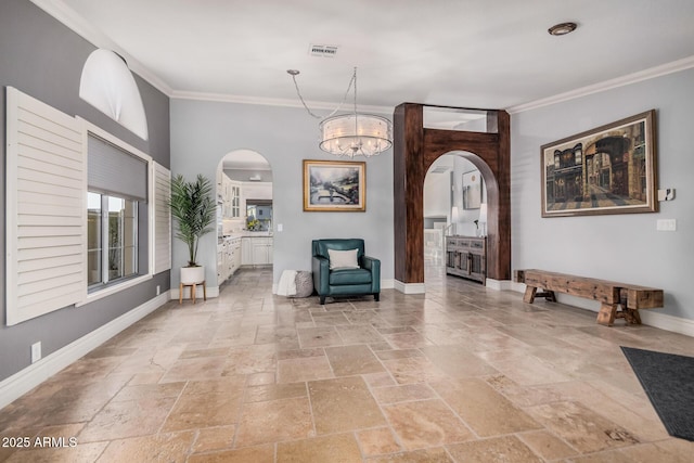 sitting room with ornamental molding and a notable chandelier