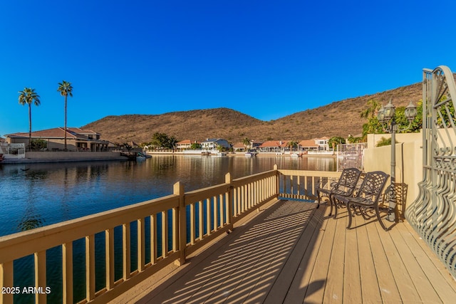 wooden terrace with a water and mountain view