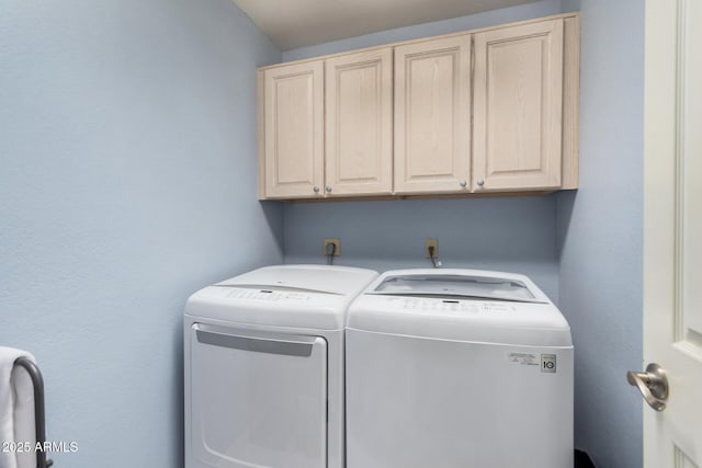 laundry room featuring washer and dryer and cabinets