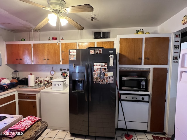 kitchen with light tile patterned flooring, washer / dryer, black refrigerator with ice dispenser, and dishwasher