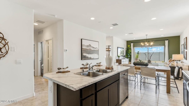 kitchen featuring stainless steel dishwasher, dark brown cabinetry, open floor plan, a chandelier, and a sink