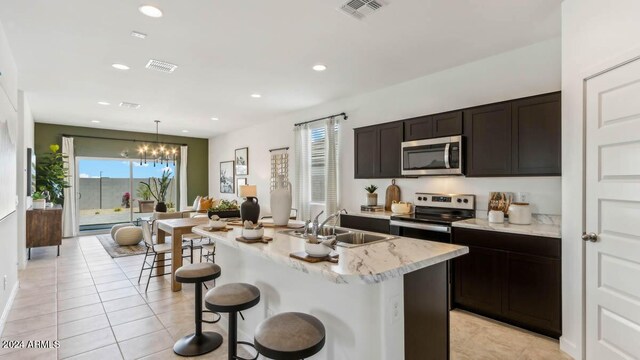 kitchen featuring visible vents, a sink, appliances with stainless steel finishes, and light tile patterned floors