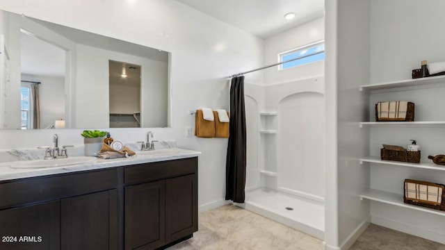 bathroom with a sink, a shower stall, and a healthy amount of sunlight