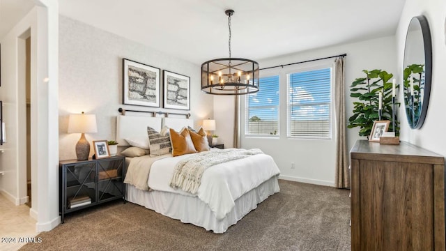 carpeted bedroom featuring baseboards and a notable chandelier