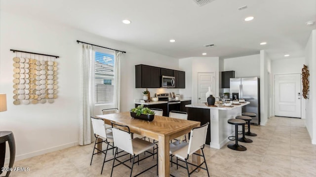 kitchen with visible vents, an island with sink, recessed lighting, light countertops, and appliances with stainless steel finishes