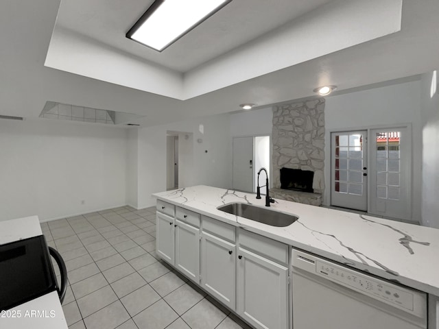 kitchen featuring visible vents, white cabinets, open floor plan, white dishwasher, and a sink