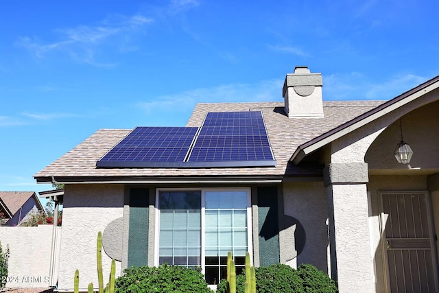 view of side of property featuring solar panels