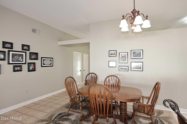 tiled dining space featuring lofted ceiling and a chandelier