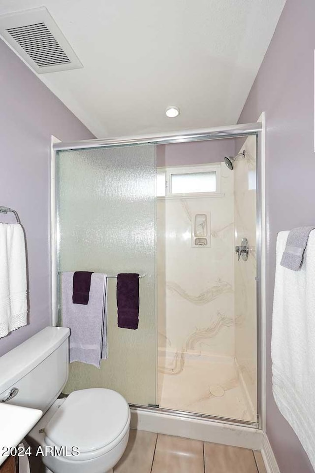 bathroom featuring vanity, toilet, an enclosed shower, and tile patterned flooring