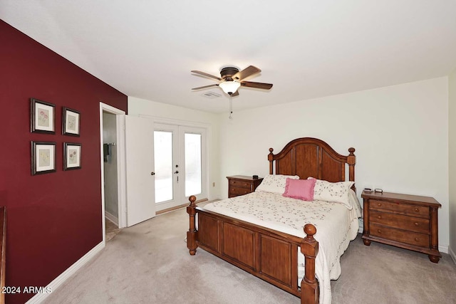 bedroom with ceiling fan, french doors, and light carpet