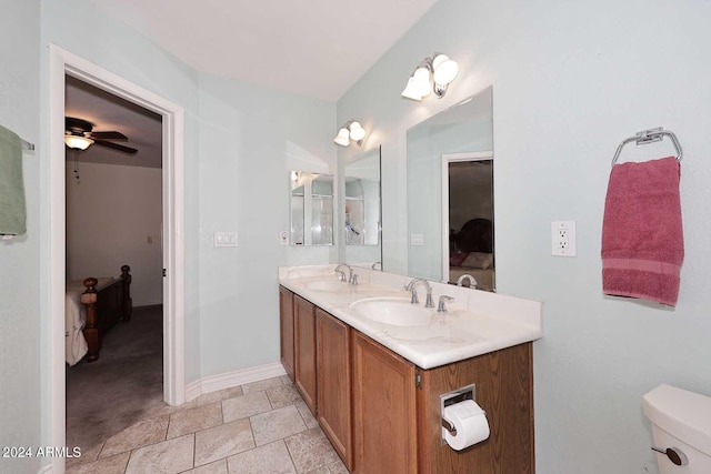 bathroom featuring toilet, ceiling fan, and vanity