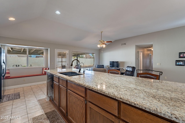 kitchen with sink, dishwasher, vaulted ceiling, and a wealth of natural light