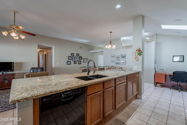 kitchen with sink, light stone counters, light tile patterned flooring, a kitchen island with sink, and black dishwasher