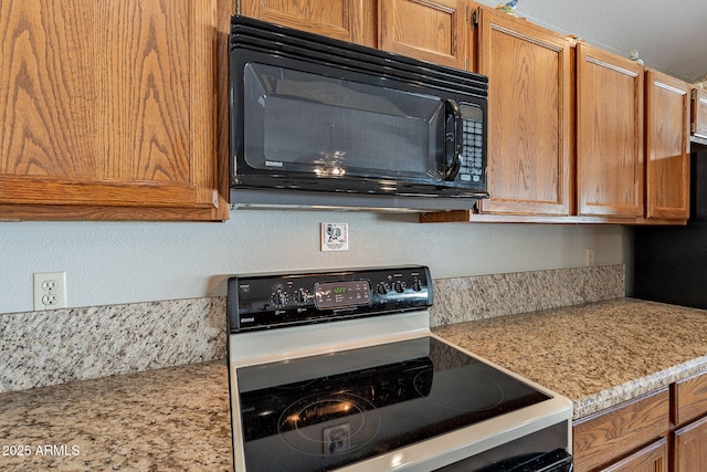 kitchen featuring black appliances and light stone countertops