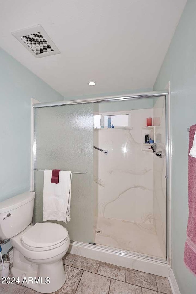 bathroom featuring toilet, vaulted ceiling, and an enclosed shower