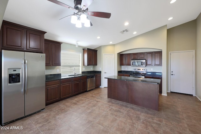 kitchen featuring dark brown cabinetry, stainless steel appliances, ceiling fan, sink, and a center island