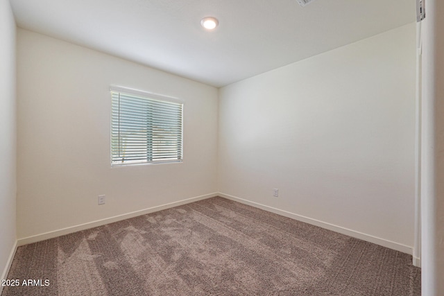 empty room featuring baseboards and carpet flooring