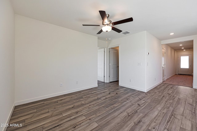 empty room with recessed lighting, visible vents, dark wood finished floors, and baseboards