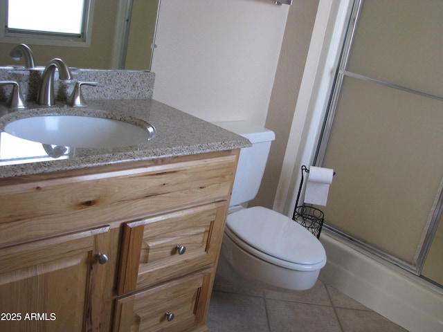 full bathroom with a shower with shower door, vanity, toilet, and tile patterned floors