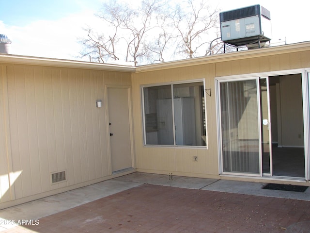 entrance to property featuring crawl space, visible vents, a patio, and central air condition unit