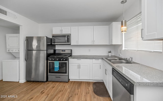 715 W Cinnabar Ave, Phoenix, AZ 85021 - kitchen with stacked washer and dryer, light wood-style flooring, visible vents, stainless steel appliances, and a sink