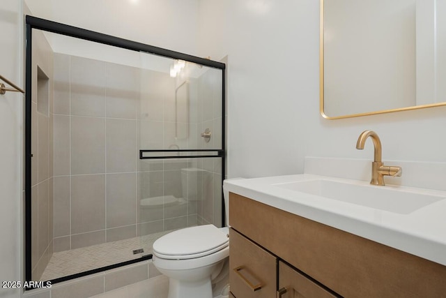 bathroom featuring a shower stall, toilet, and vanity