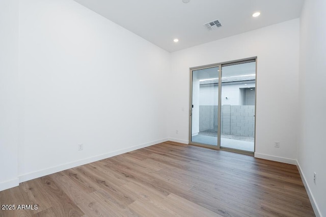 unfurnished bedroom featuring recessed lighting, wood finished floors, access to exterior, baseboards, and visible vents