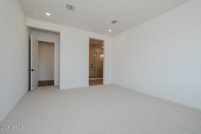 empty room with visible vents, recessed lighting, and light carpet