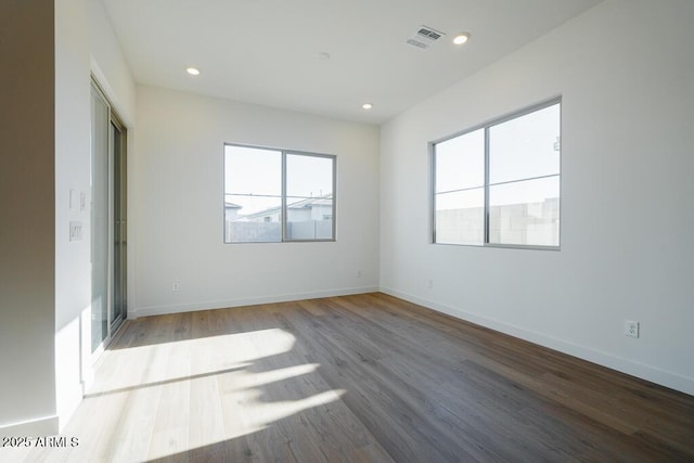 unfurnished bedroom featuring baseboards, recessed lighting, wood finished floors, and visible vents