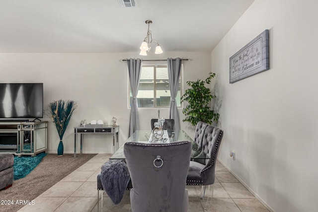 tiled dining room with a chandelier